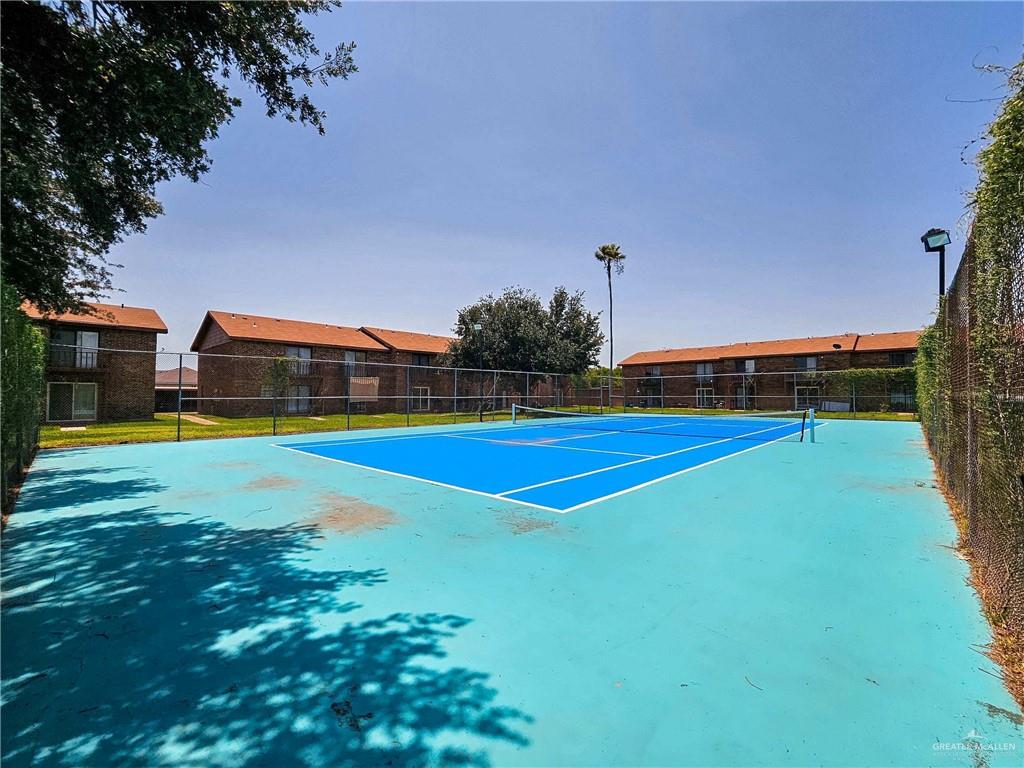 2201 South Jackson Road, Unit 2I Pharr, TX 78577 - Photo 17 of 23 Full-size tennis court featuring a vibrant blue playing surface and perimeter fencing