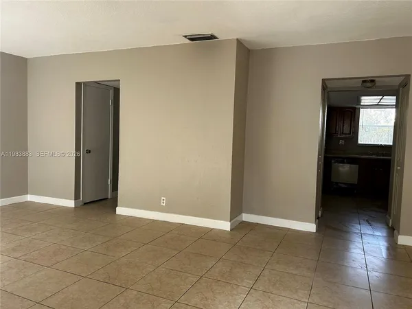 a view of an empty room with closet and a window
