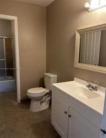 a bathroom with a sink a toilet and mirror
