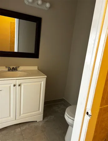 a utility room with a sink a toilet and a mirror
