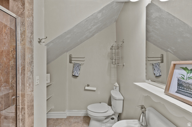 148 South 300 East Logan, UT 84321 - Photo 10 of 29 Bathroom featuring a glass-enclosed shower with stone-finish tile, a white toilet, and a vanity with a white basin sink