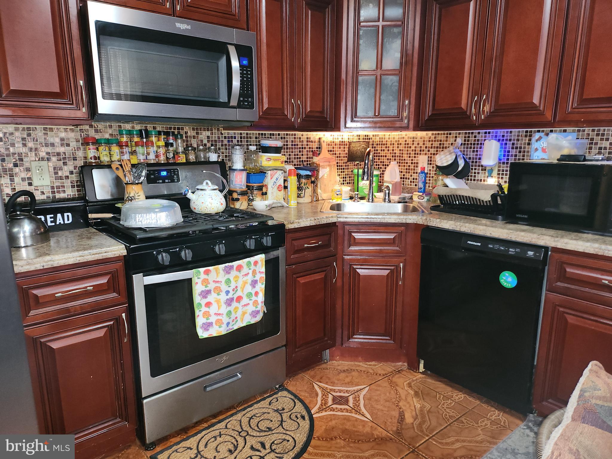 6002 North 19th Street Philadelphia, PA 19141 - Photo 2 of 25 a kitchen with stainless steel appliances granite countertop a stove microwave and sink