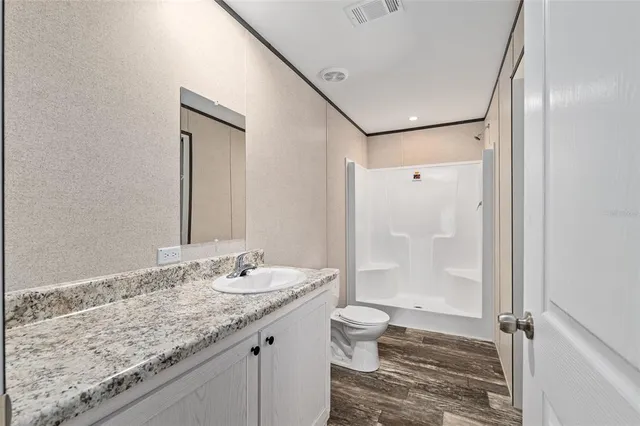 a bathroom with a granite countertop sink toilet and shower