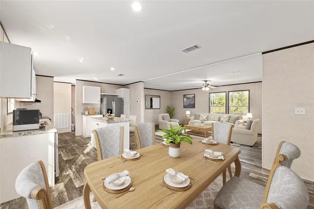 a view of a dining room with furniture a kitchen and chandelier