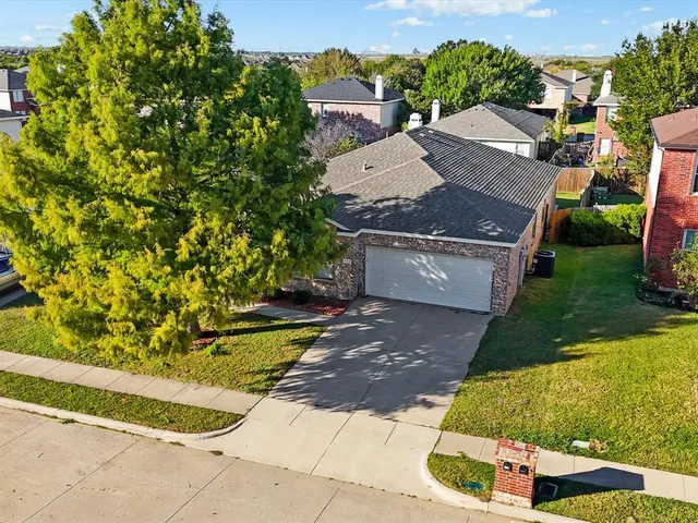 a front view of a house with yard and trees