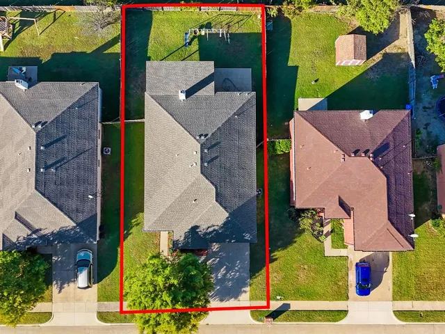 an aerial view of a house with garden space and a patio