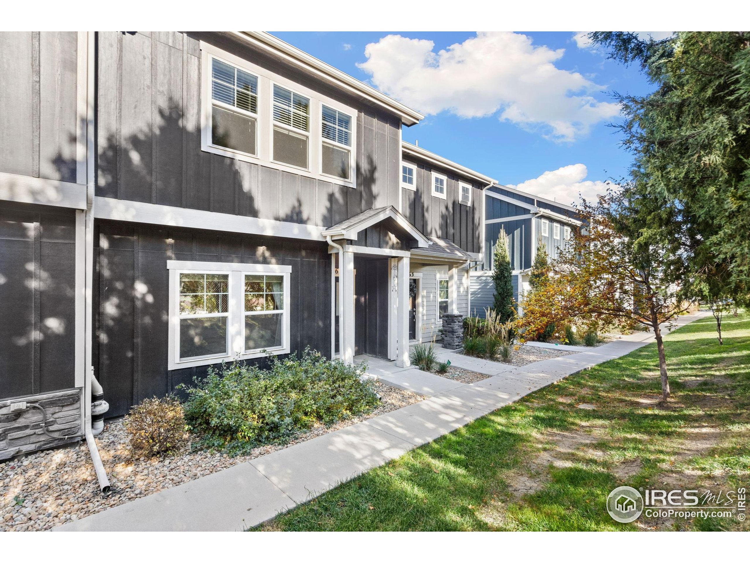 865 Winding Brook Drive Berthoud, CO 80513 - Photo 23 of 27 a view of a brick house with many windows next to a yard