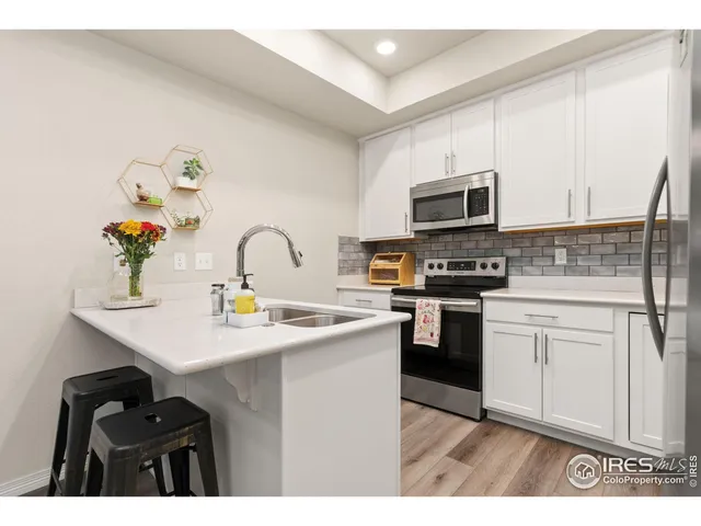 a kitchen with stainless steel appliances a sink a stove top oven a counter space and cabinets
