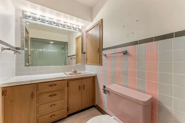 a bathroom with a granite countertop sink a toilet and a mirror