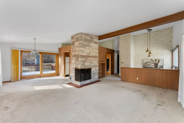 a view of an empty room with a fireplace and a window