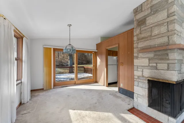 a view of an empty room with a fireplace and a window
