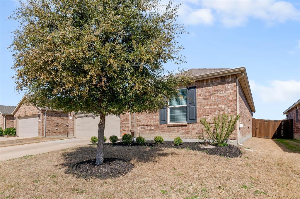 3125 Adrian Creek Drive Little Elm, TX 75068 - Photo 1 of 22 View of property hidden behind natural elements with brick siding, driveway, an attached garage, and fence