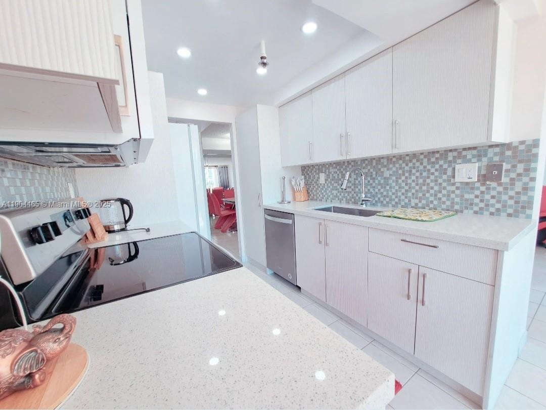 Sunny Isles Beach Sunny Isles Beach, FL 33160 - Photo 5 of 11 a kitchen with a sink a stove and cabinets