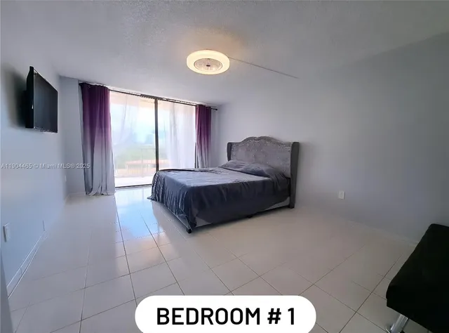 a bedroom with a bed and a television