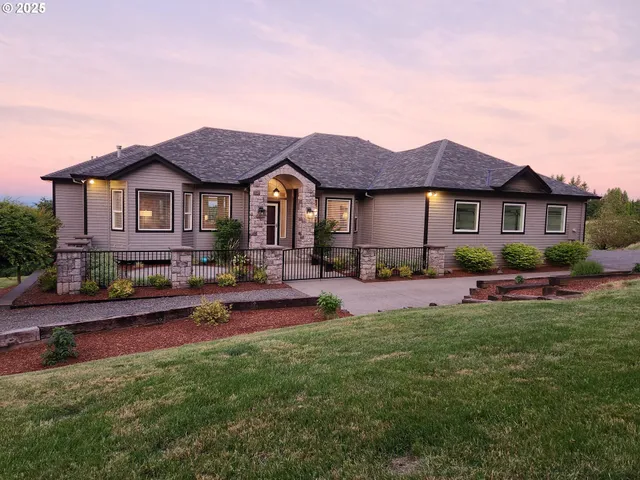 a front view of a house with a garden and plants