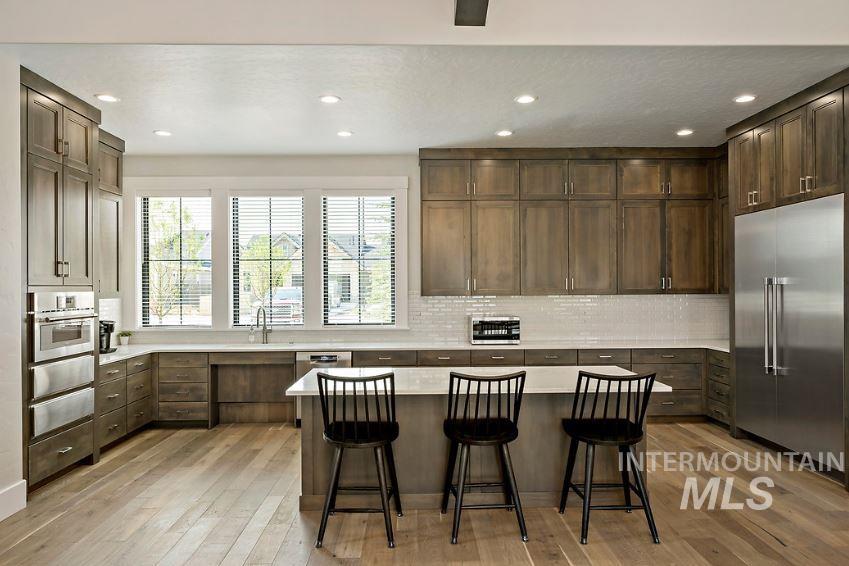 3480 East Macumbo Lane Meridian, ID 83642 - Photo 34 of 43 Kitchen featuring stainless steel appliances, recessed lighting, a kitchen island, a kitchen bar, and decorative backsplash