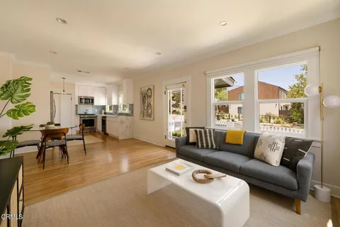 a kitchen with stainless steel appliances kitchen island granite countertop a table chairs and a refrigerator