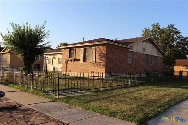 a view of a house with a wooden fence