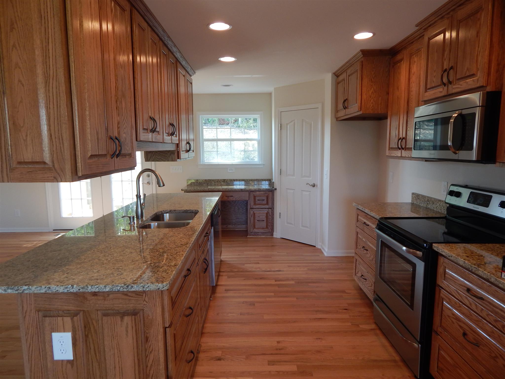 1545 Heller Ridge Spring Hill, TN 37174 - Photo 5 of 19 a kitchen with stainless steel appliances granite countertop wooden cabinets a stove top oven a sink and dishwasher