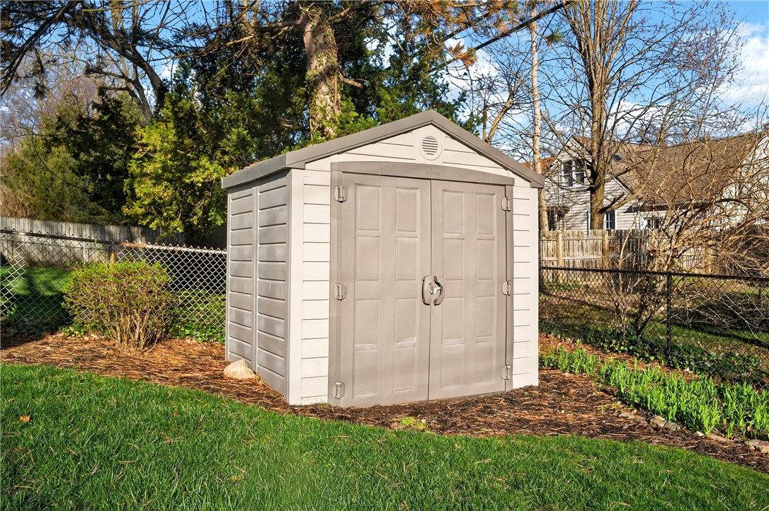 1237 Laurelwood Road Dayton, OH 45409 - Photo 40 of 56 This spacious backyard offers a perfect blend of natural beauty and practical storage solutions.