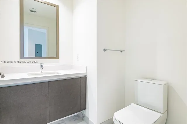 a bathroom with a toilet a sink and mirror