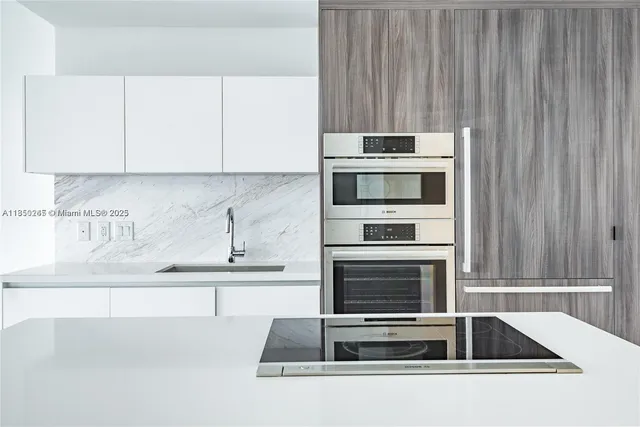 a kitchen with granite countertop a sink stove and cabinets