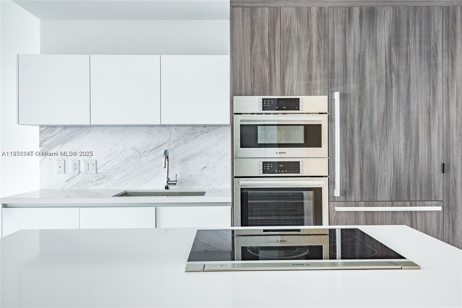 851 Northeast 1st Avenue, Unit 2100 Miami, FL 33132 - Photo 2 of 40 a kitchen with granite countertop a sink stove and cabinets