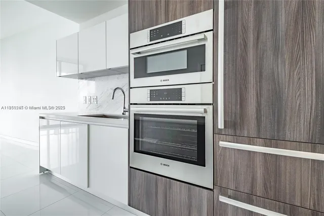 a kitchen with granite countertop white cabinets stainless steel appliances and sink