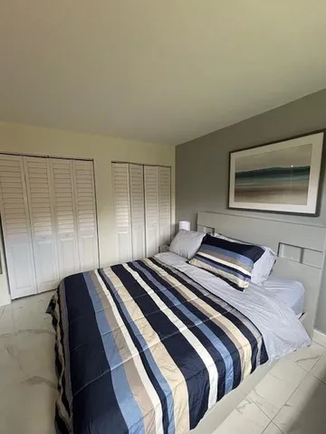 a bedroom with a bed and a view of balcony