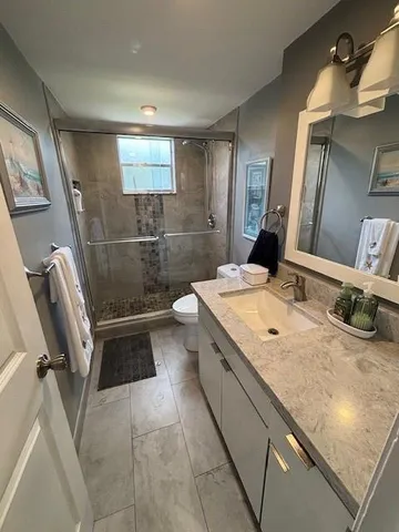 a bathroom with a granite countertop sink a mirror and a bathtub