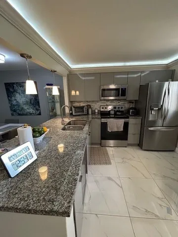 a kitchen with stainless steel appliances granite countertop a sink a stove counter space and cabinets