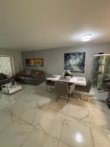 a living room with furniture a piano and a flat screen tv