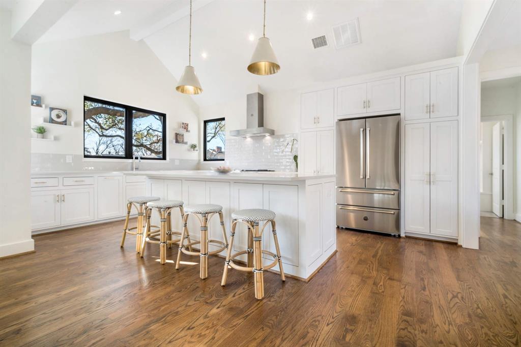 a kitchen with stainless steel appliances a dining table chairs and chandelier