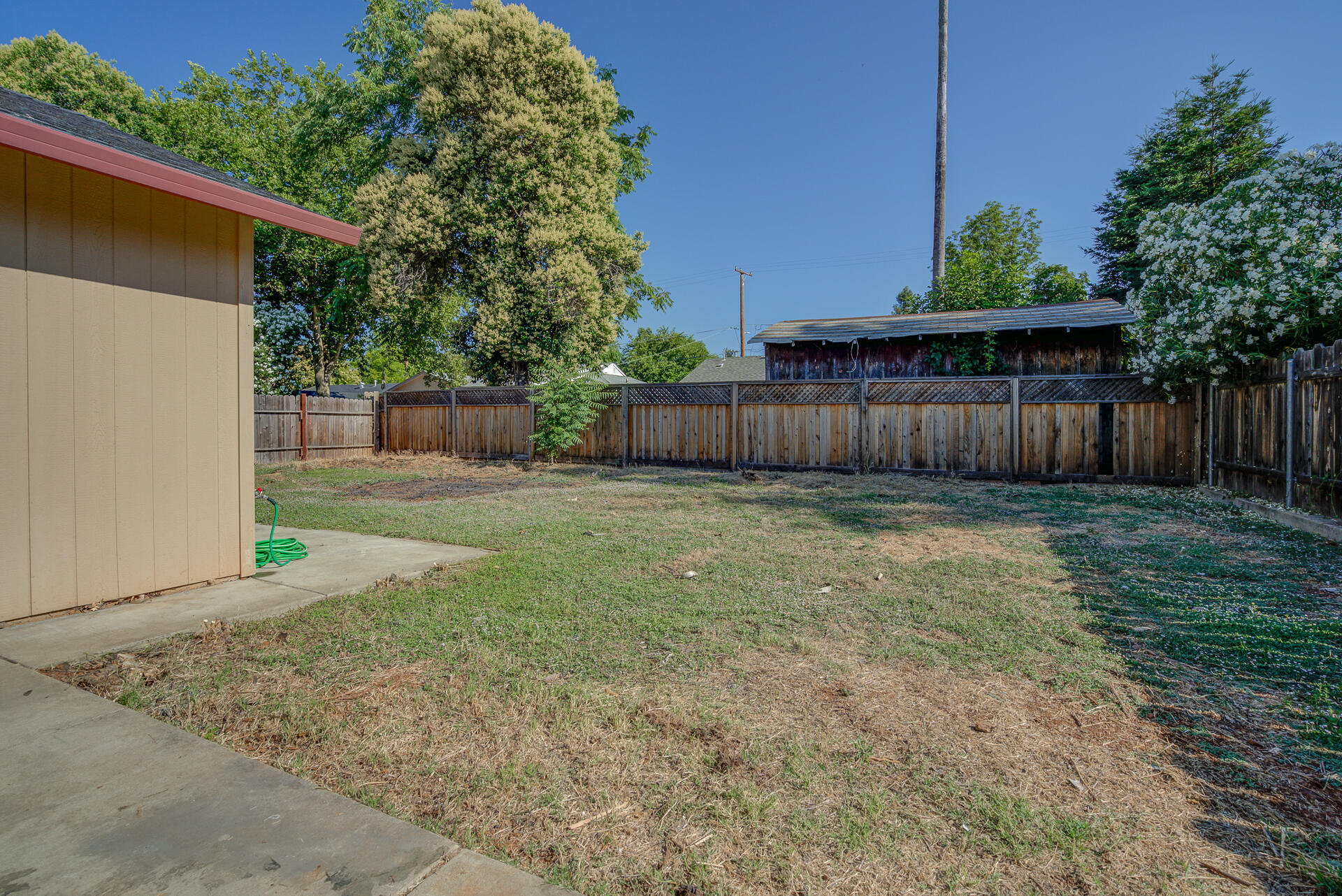1101 Layton Road Redding, CA 96002 - Photo 30 of 37 a view of a backyard with a tree and wooden fence