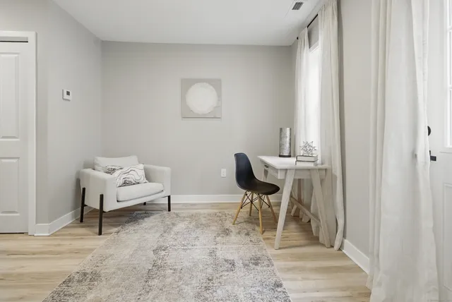 a view of a workspace with furniture and wooden floor