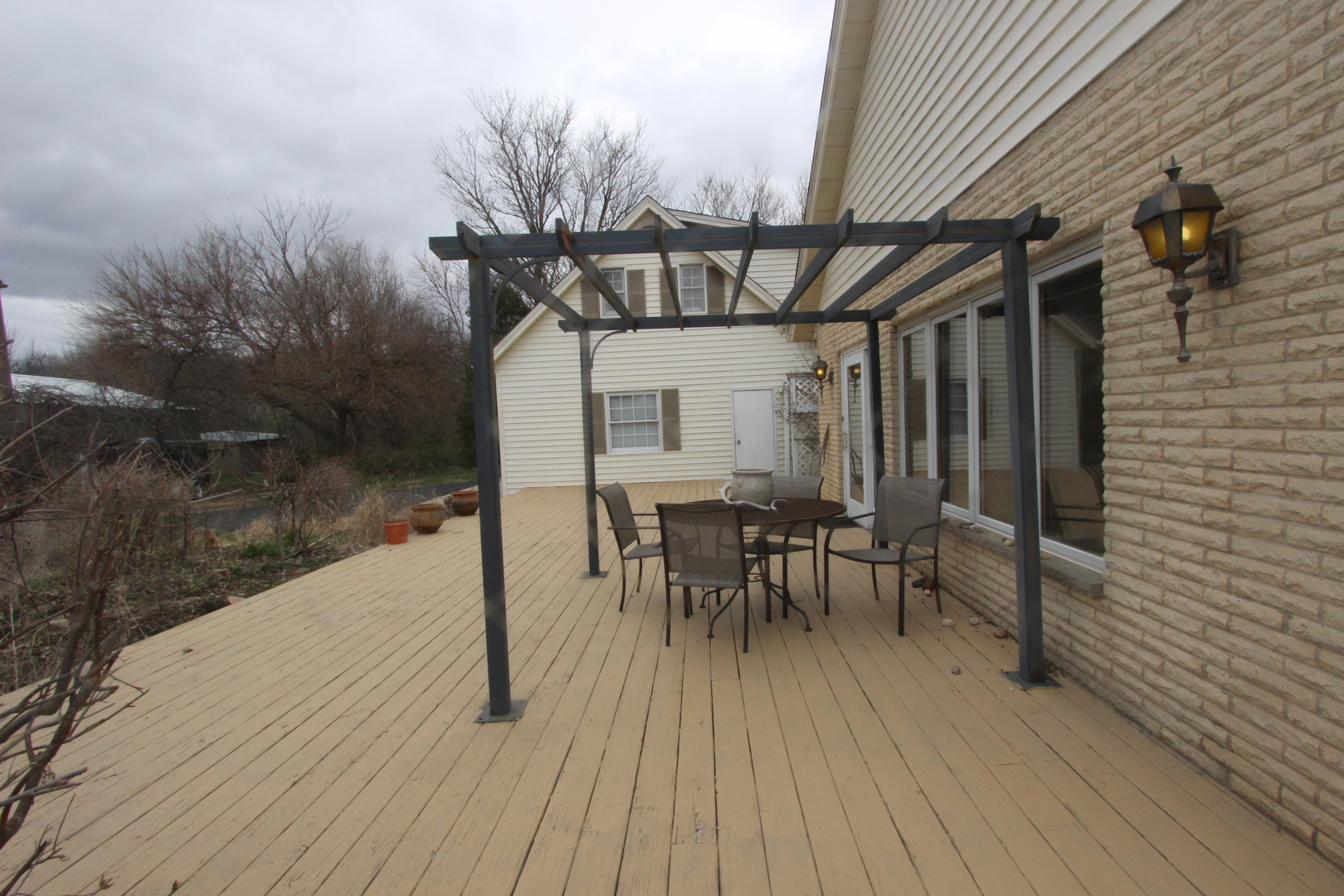 21614 River Road Marengo, IL 60152 - Photo 30 of 45 a view of a patio with table and chairs with wooden floor and fence
