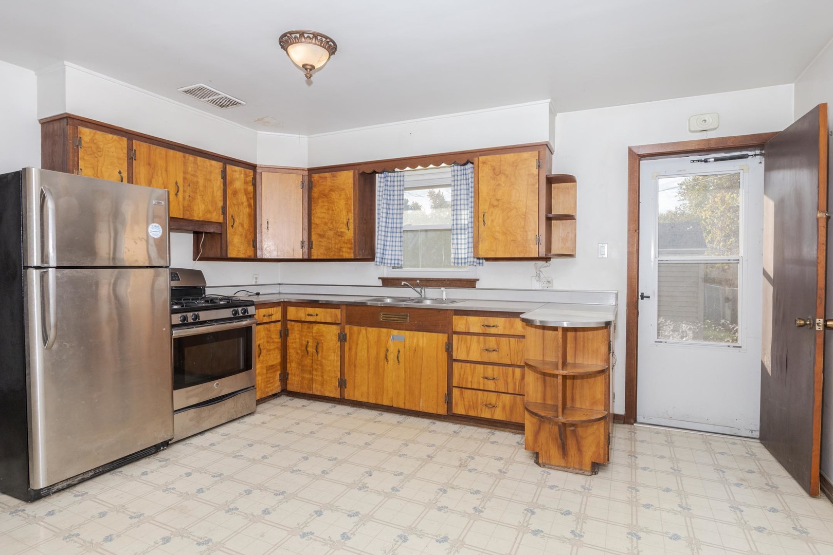 412 East Prairie Street Pontiac, IL 61764 - Photo 16 of 26 a kitchen with granite countertop a stove a sink cabinetry and a refrigerator