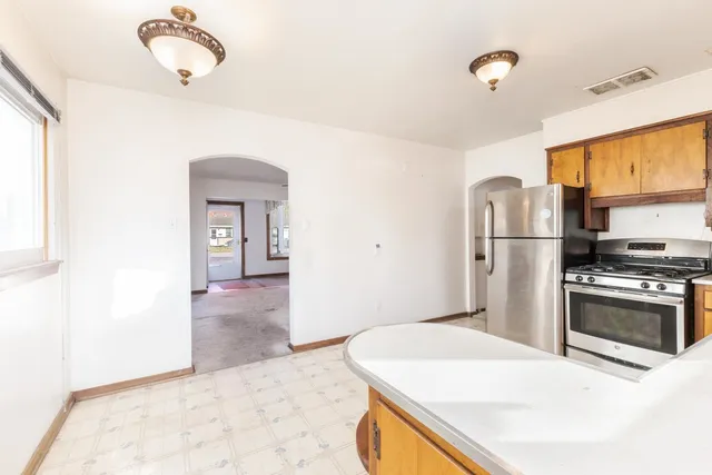 a kitchen with stainless steel appliances kitchen island a refrigerator sink and stove