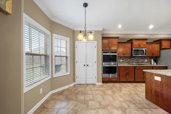 a open kitchen with stainless steel appliances granite countertop a stove and refrigerator