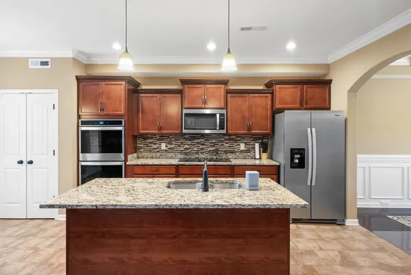 a kitchen with stainless steel appliances granite countertop a sink refrigerator and microwave