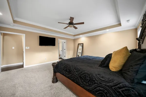 a bedroom with a large bed and a chandelier