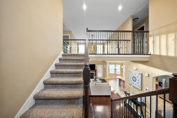 a view of a hallway with wooden floor and staircase