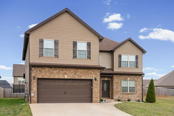 a front view of a house with a yard and garage