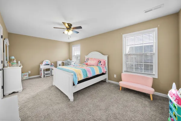 a spacious bedroom with a bed and a chandelier