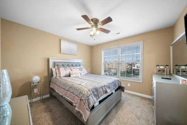 a bedroom with a bed and ceiling fan