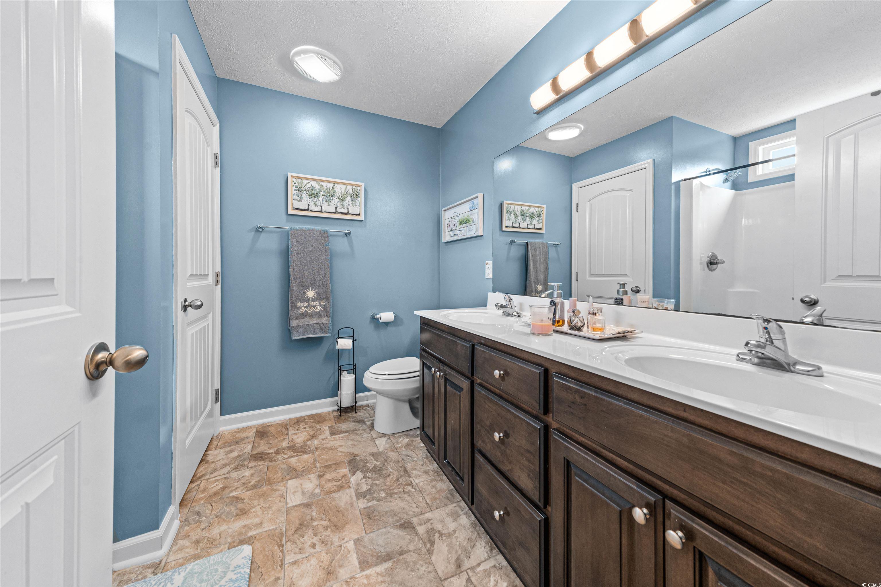 283 Beulah Circle Conway, SC 29527 - Photo 16 of 32 Bathroom featuring double vanity, stone finish floors, and a shower
