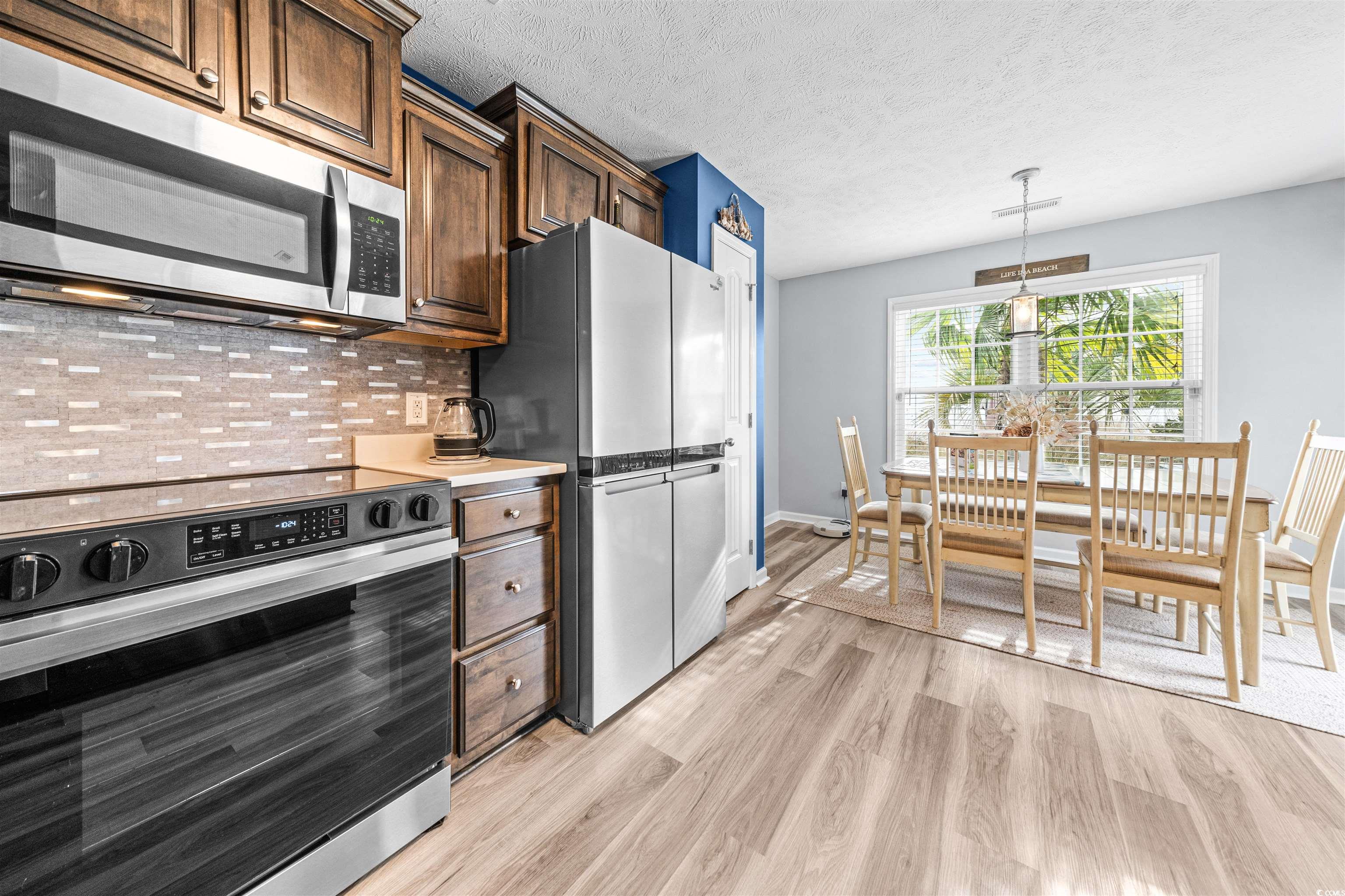 283 Beulah Circle Conway, SC 29527 - Photo 7 of 32 Kitchen featuring stainless steel appliances, light countertops, tasteful backsplash, a textured ceiling, and decorative light fixtures