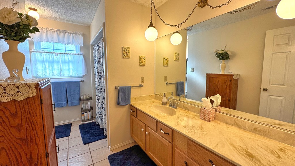 305 Rock Ridge Kerrville, TX 78028 - Photo 19 of 36 a bathroom with a granite countertop sink and a mirror