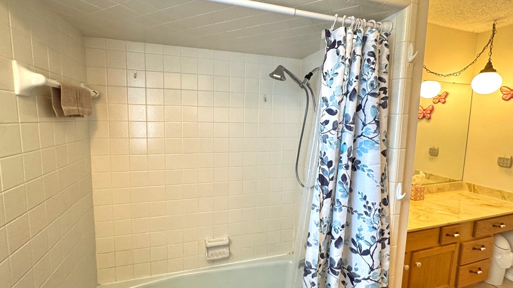 305 Rock Ridge Kerrville, TX 78028 - Photo 20 of 36 a bathroom with a shower curtain and a window