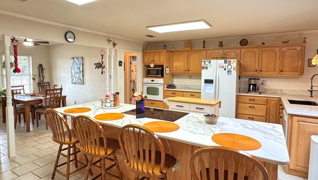 305 Rock Ridge Kerrville, TX 78028 - Photo 8 of 36 a kitchen with granite countertop a dining table chairs sink stove and refrigerator